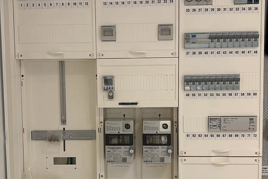 Neu aufgebauter Zählerschrank mit beschrifteten Sicherungen und zwei Zählern