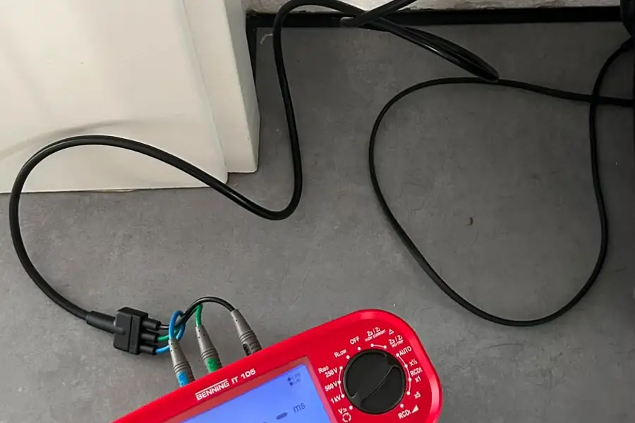 Installationstester an einer Steckdose während der Messung