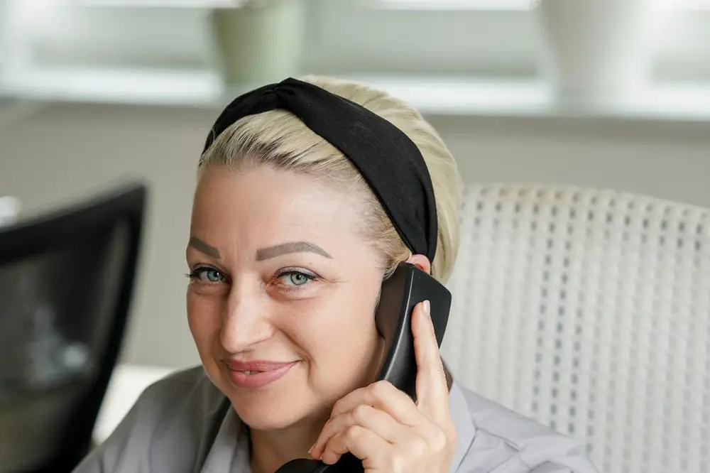 Mitarbeiterin im Büro am Telefon