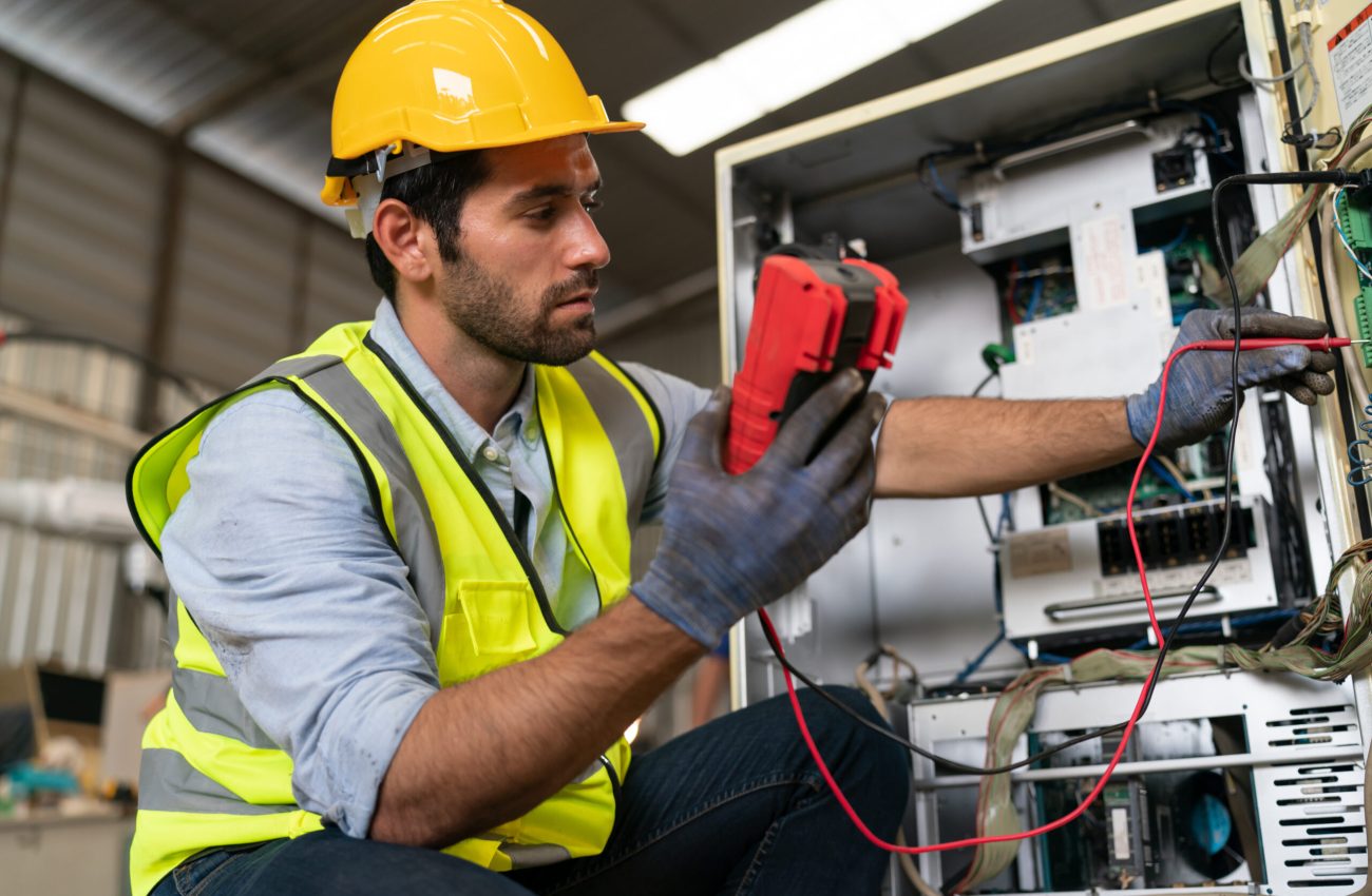 Robotics engineer working on maintenance of modern robotic arm in factory warehouse